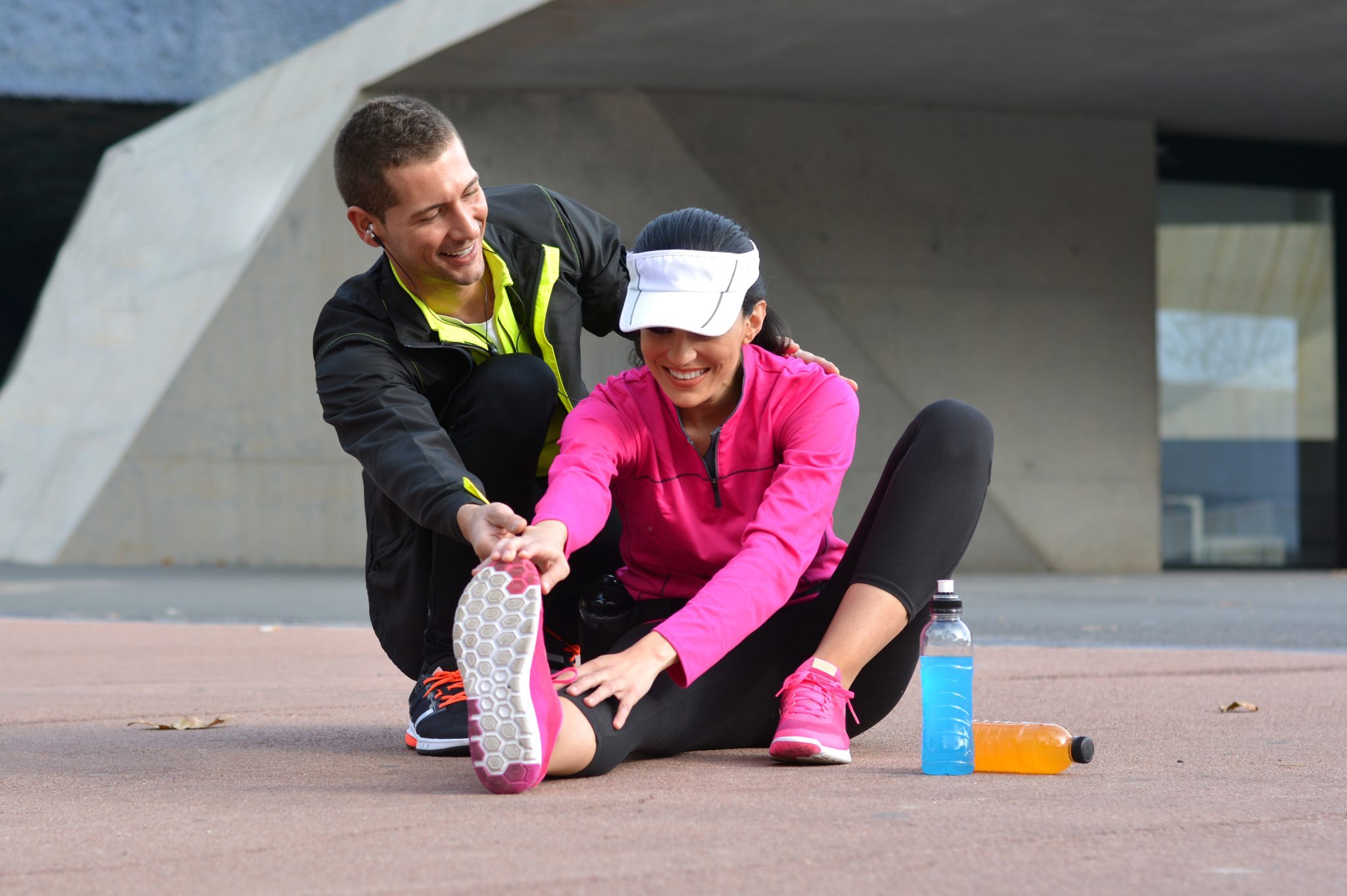 pareja haciendo estiramientos despues de correr por la ciudad